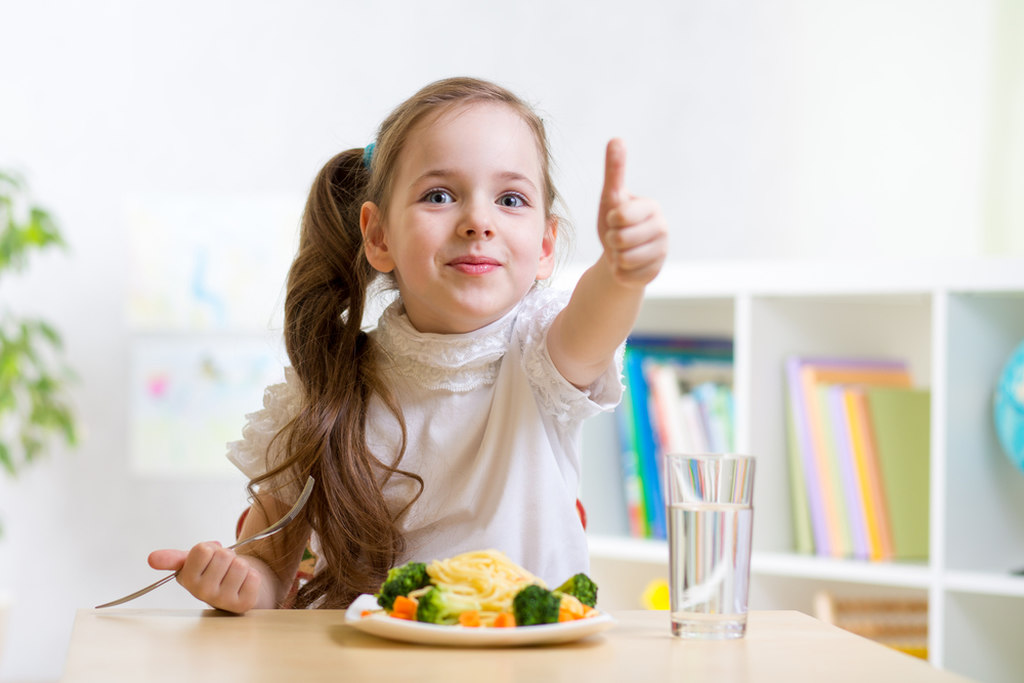 criança fazendo sinal positivo para alimentação saudável infantil 